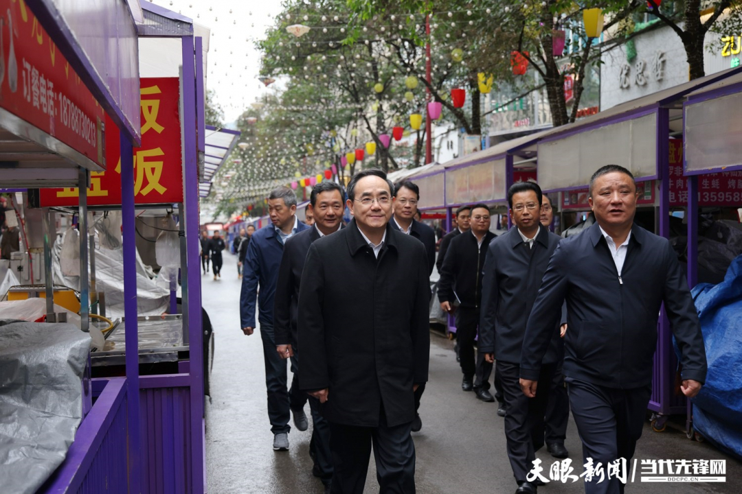 图为徐麟在盘州市亦资街道三峡北路小吃一条街，察看店面摊点管理情况。.jpg