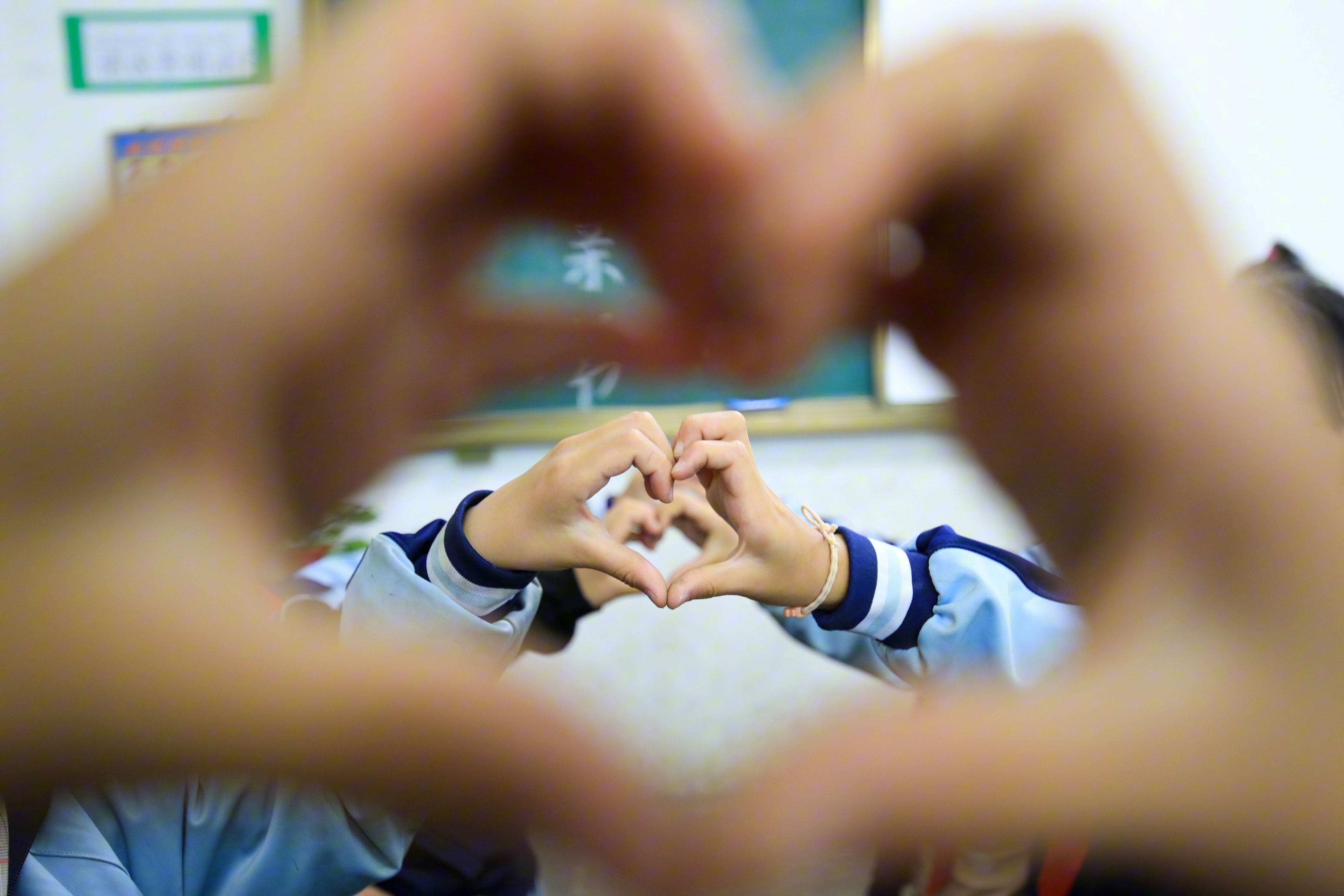 480736-2022年5月7日，贵州省从江县刚边乡中心小学学生在母亲节主题班会上“比心”。.JPG