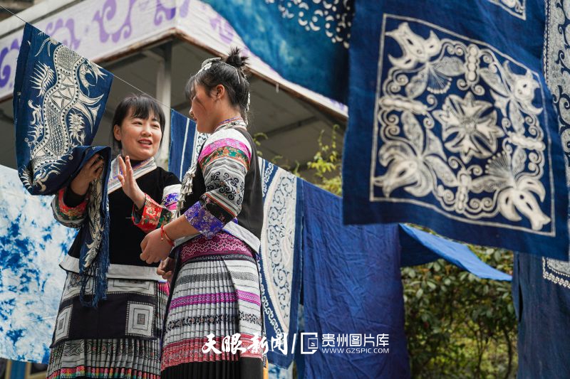 862721-4月8日，在织金县民族工艺文化传承中心，蜡染技艺非遗传承人蔡群在与绣娘交流蜡染制作工艺。.jpg