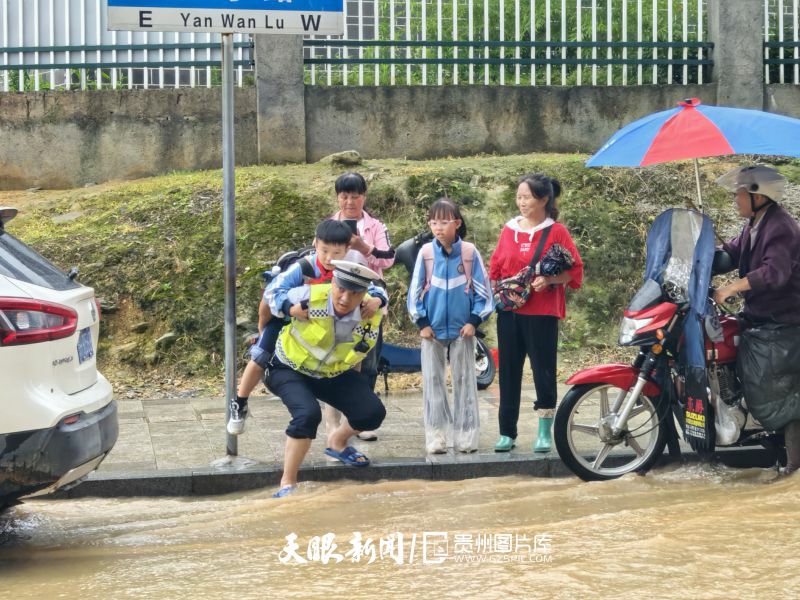 887721-图为6月23日，交警背学生趟水过街。.jpg