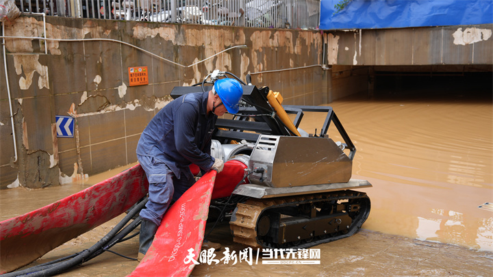 南方电网公司工作人员正在给排涝机器人接上排水管，准备为地下停车场排涝。龙定锦 摄.jpg
