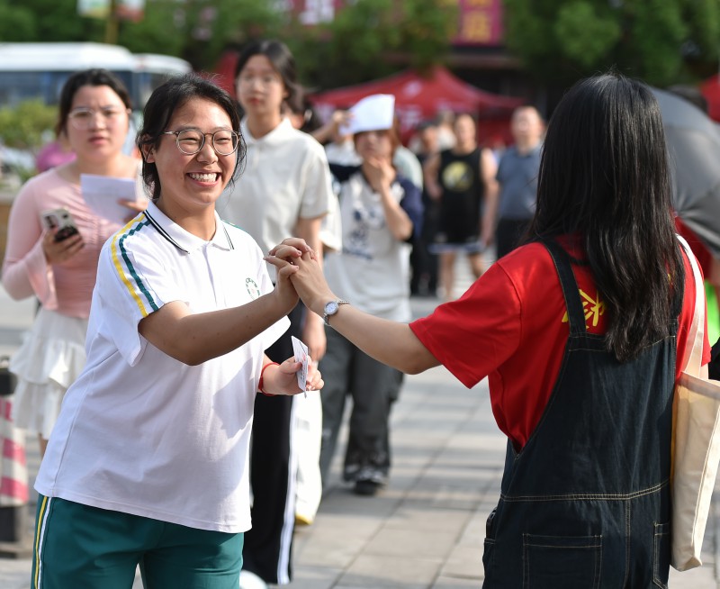 882661-6月7日，在松桃苗族自治县民族中学考点，一名考生与老师击掌加油。.jpg