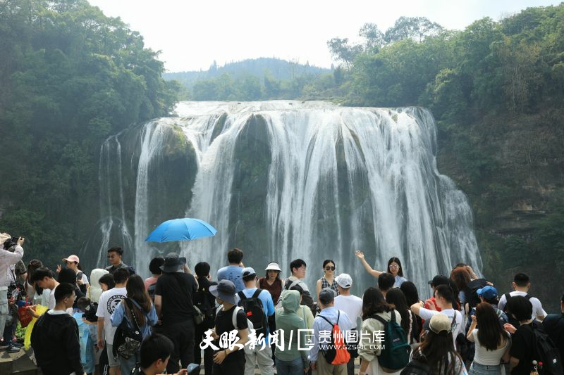 871262-图为5月4日，在黄果树景区，黄果树大瀑布奔腾的水流飞泻而下，气势磅礴，吸引了大量游客驻足欣赏并拍照打卡。.jpg