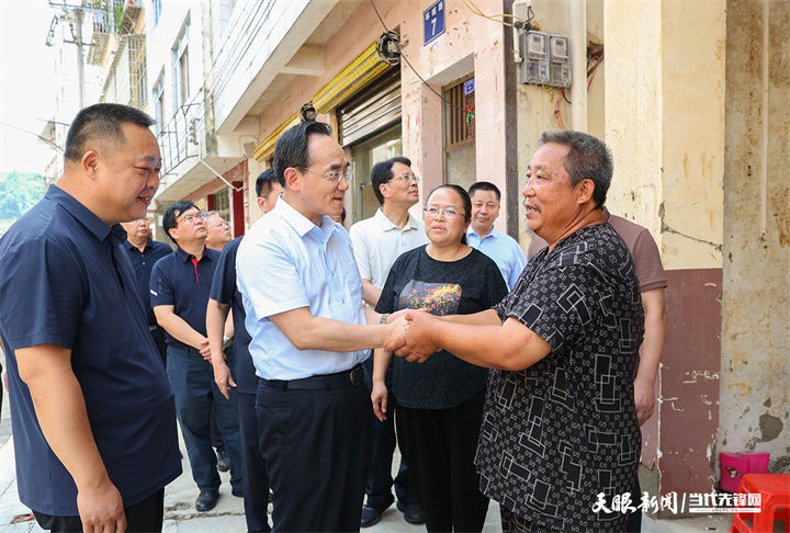 图为徐麟在从江县城老街亲切看望慰问受灾群众。.jpg