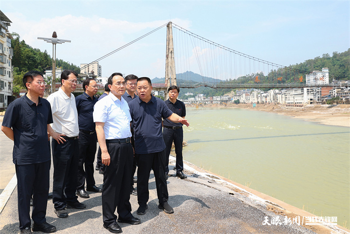 图为徐麟在从江县察看桥梁、河道堤坝，了解基础设施损毁及修复情况。.jpg