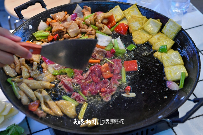 663538-2023年10月2日，夜幕下的贵州省贵阳市青云路青云市集特色美食区域的一店主在制作烧烤美食。.jpg