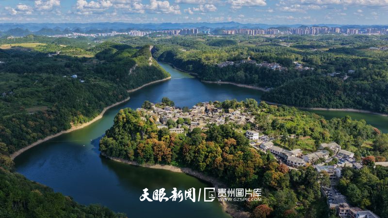 910053-2025年9月1日，贵州省贵阳市花溪区石板镇镇山村，布依族传统石板建筑群与绚丽多彩的森林植被、蓝天白云等交相辉映，构成了一幅壮美的人与自然和谐共生、保护与发展的乡村画卷。.jpg