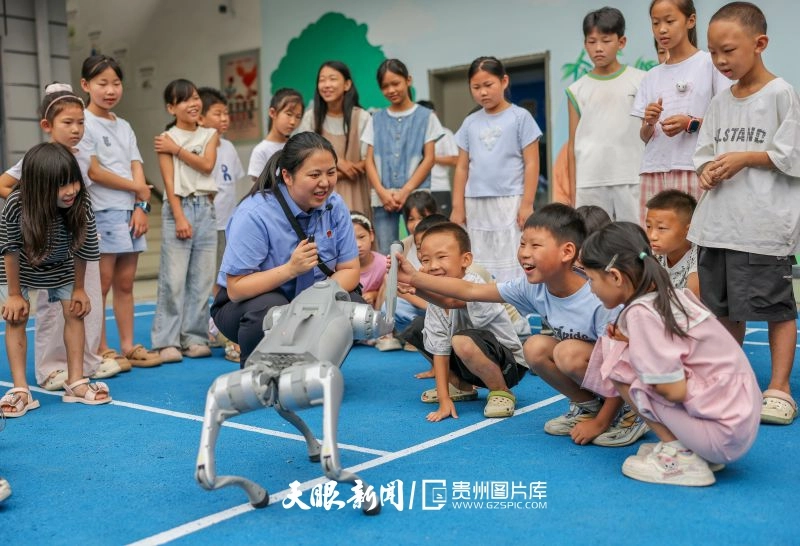 1023745-2026年8月18日，在贵州省铜仁市玉屏侗族自治县大龙街道德龙第三社区易地扶贫搬迁安置点，学生在与机器狗互动。.jpg