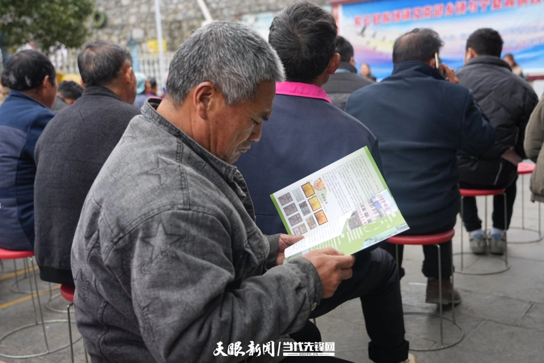 3 猴场镇曙光村村民李枝国正在看此次招聘会的宣传资料.jpg