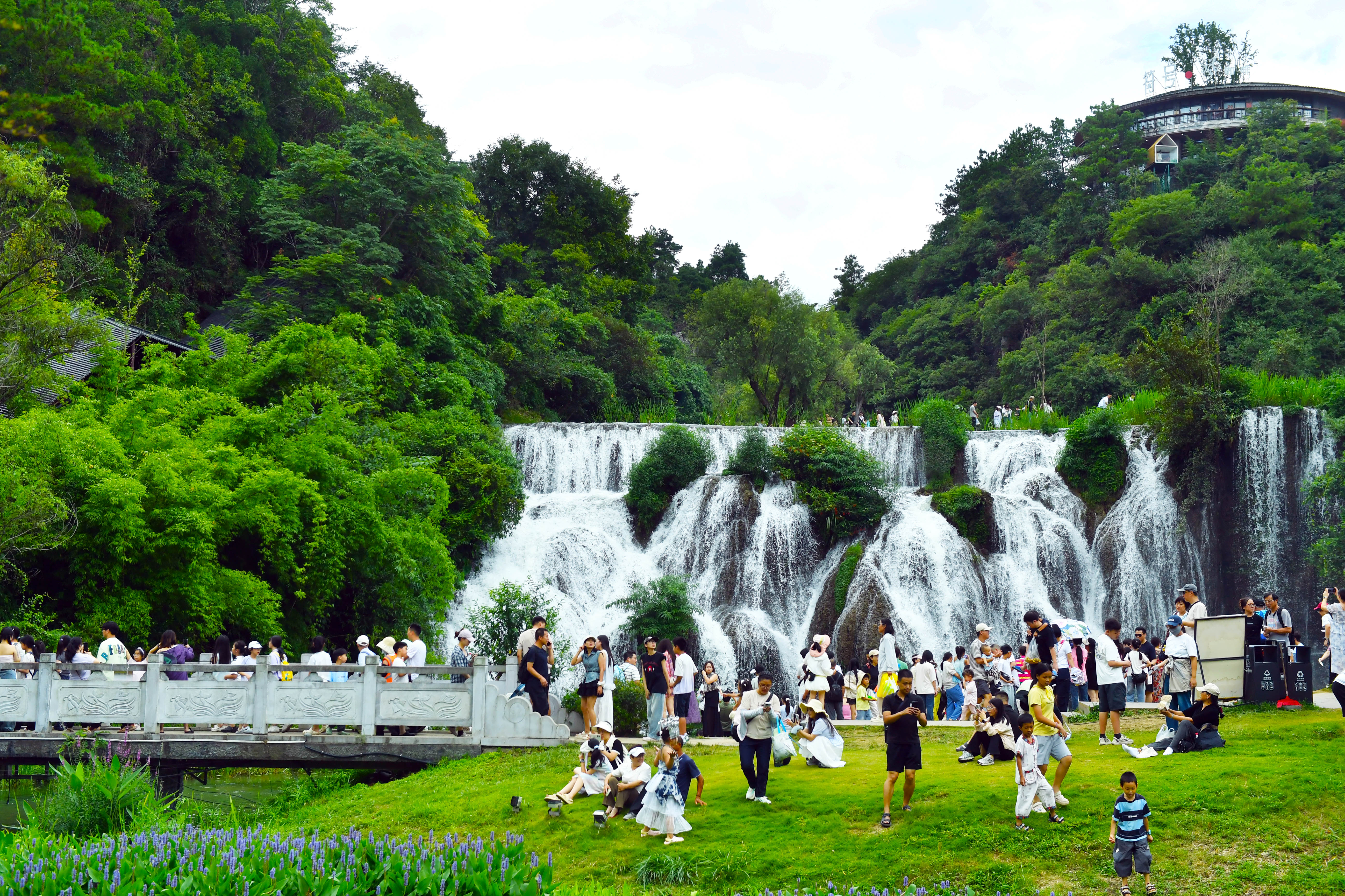 8月4日，游客在贵阳天河潭旅游度假区卧龙飞瀑景点观光游玩。作为天河潭标志性核心景观，卧龙飞瀑水流倾泻、绿意环抱，凉爽宜人的环境深受游客喜爱。暑期避暑季来临，天河潭景区依托优越的生态山水资源，成为省内外游客夏日出游、避暑纳凉的热门打卡点位，景区客流稳步攀升，文旅市场持续升温。.JPG